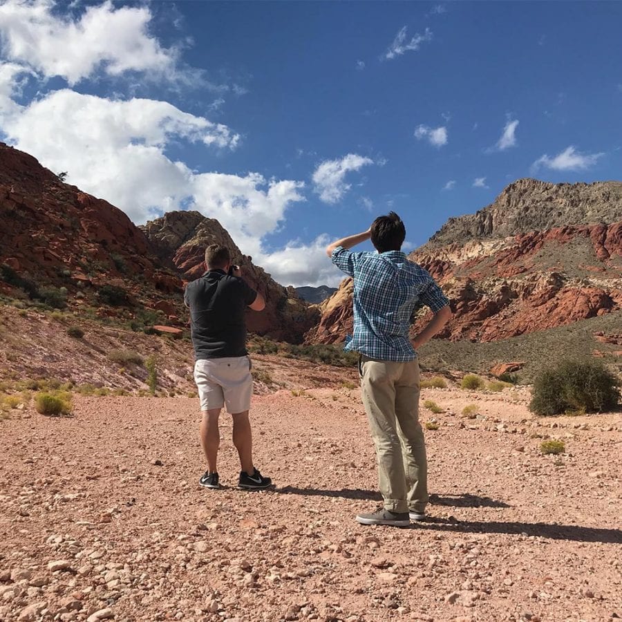 Two people standing out in the desert scouting a location for a video shoot